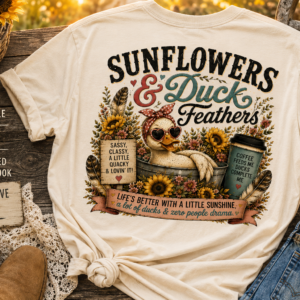Vintage-style graphic t-shirt featuring a duck surrounded by sunflowers with rustic farmhouse accents, playful quotes, and a cozy country aesthetic.