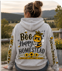 Bee Happy Homestead hoodie featuring a cheerful bee, sunflowers, daisies, floral sleeve designs, Hunniford Acres LLC logo, and “Work Hard • Stay Humble • Be Kind” message.